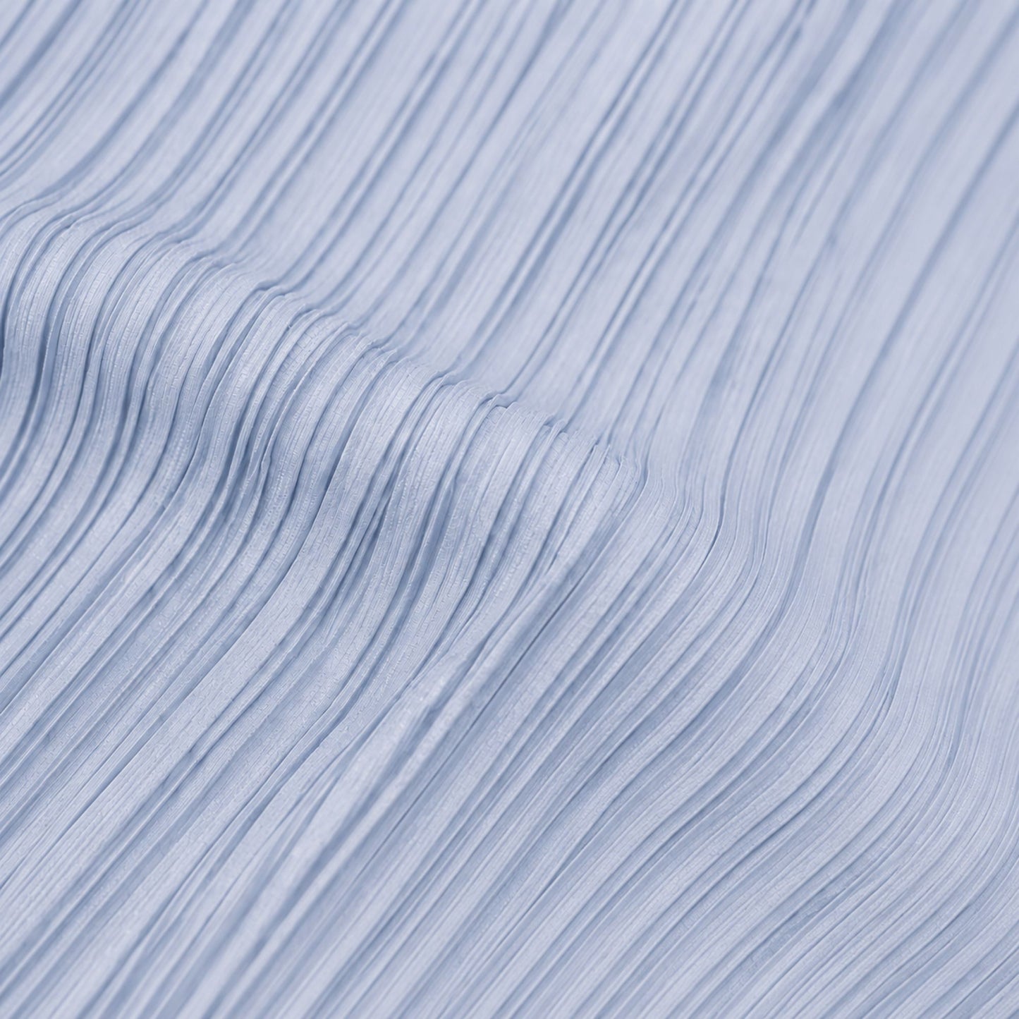 Close-up view of blue pleated polyester fabric showing the textured lightweight material and fine pleat detail.