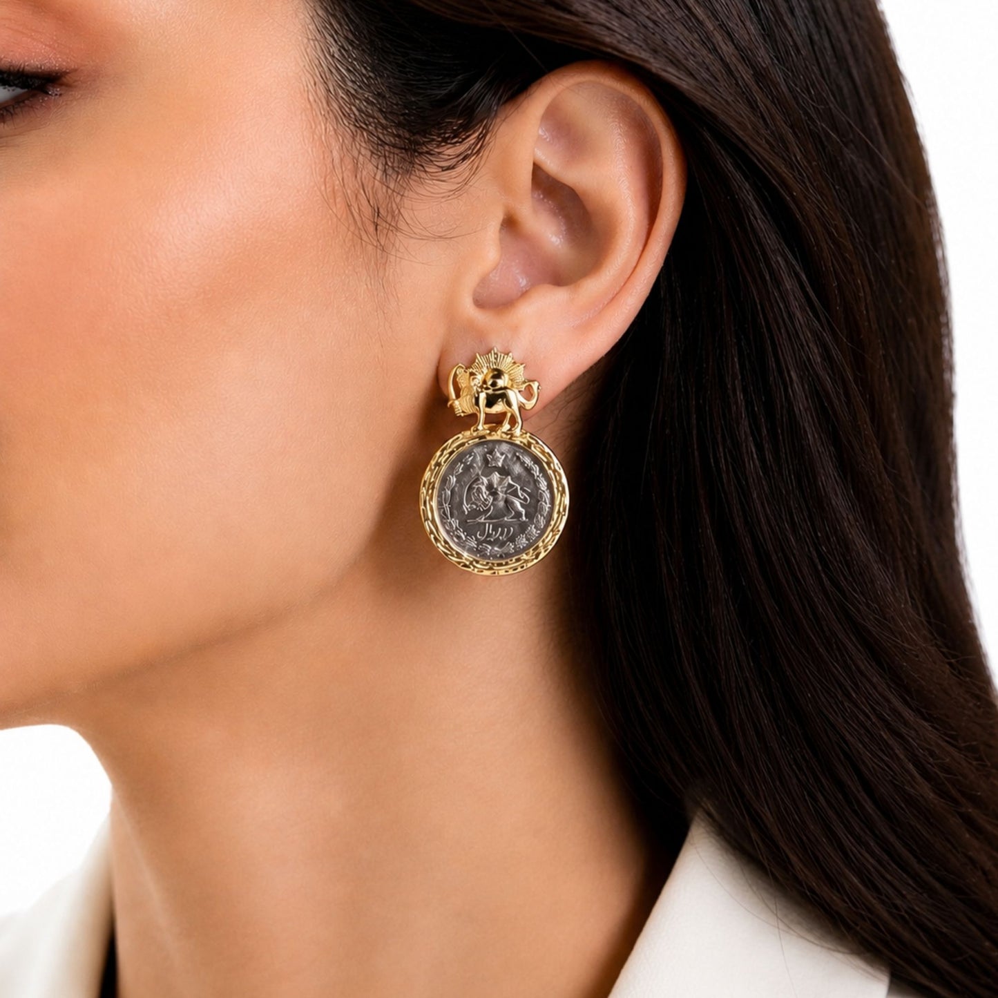 Woman wearing gold-plated Pahlavi coin statement earrings with crown detail