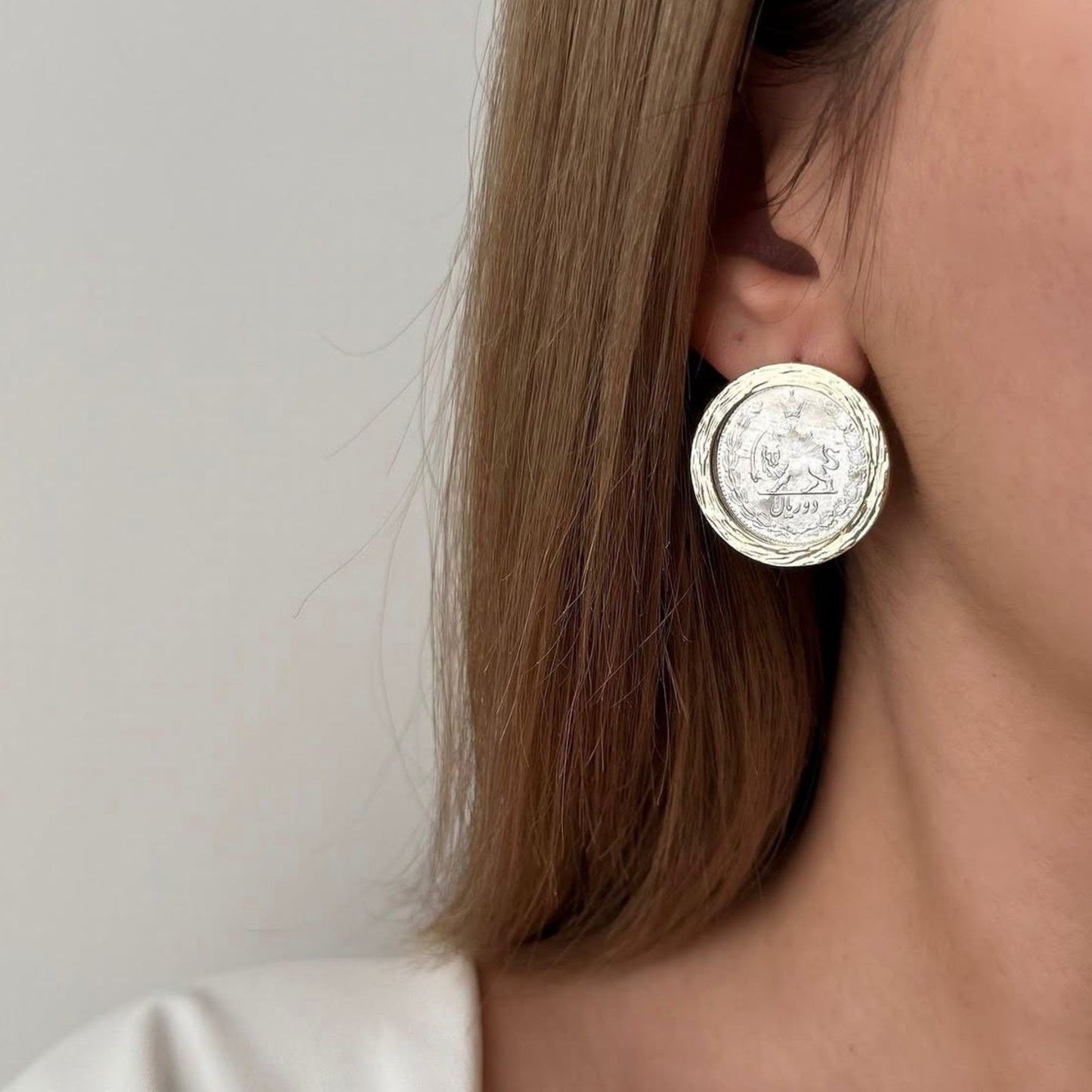 Handmade Persian-inspired coin stud earrings displayed on a soft neutral boho background