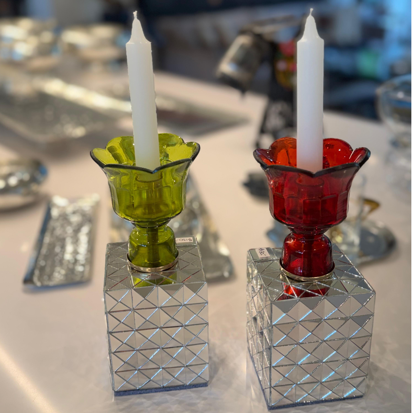 Handcrafted mirror mosaic glass candle holders in Ruby Red and Light Olive Green displayed on kitchen counter.