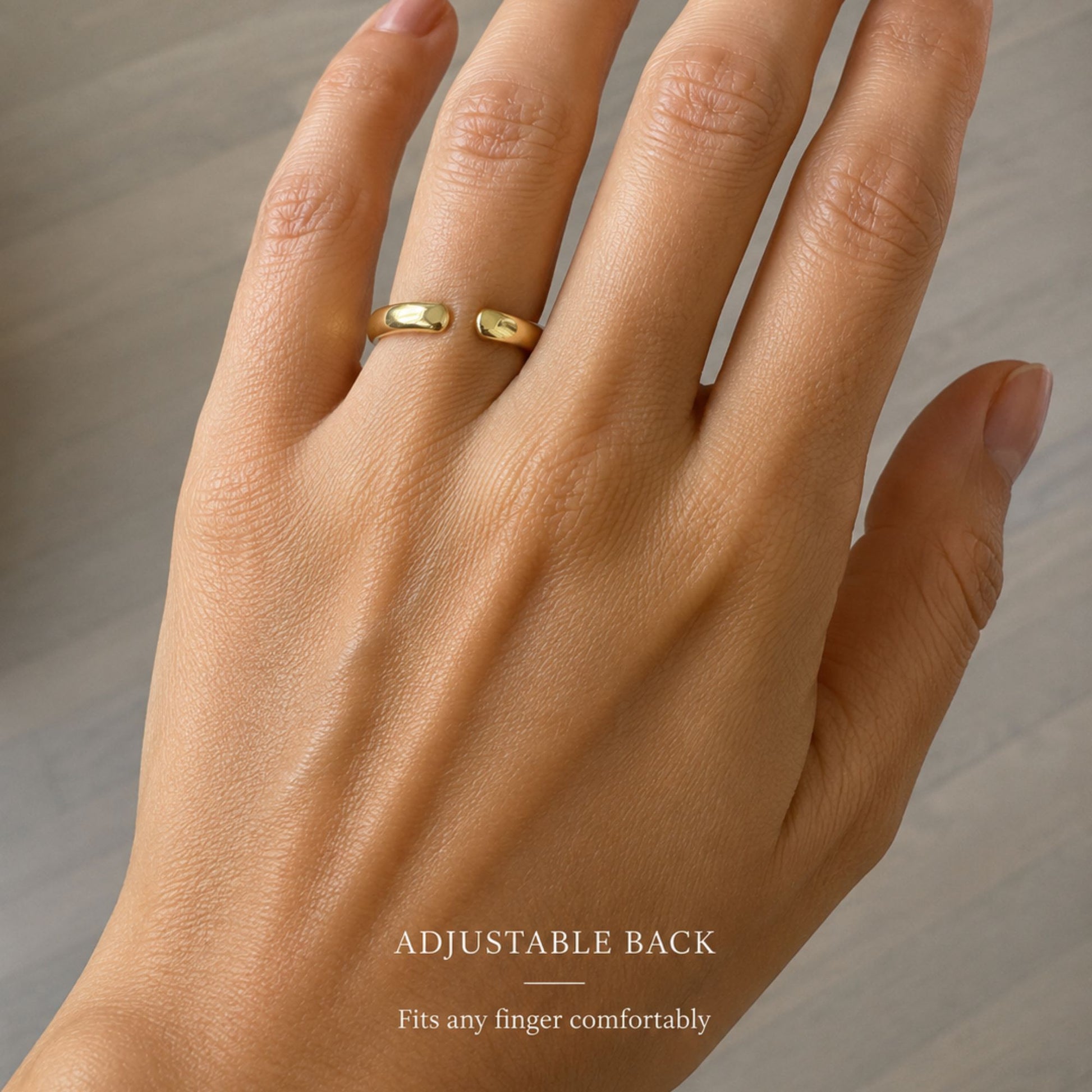 Gold ring on a hand with an adjustable back feature