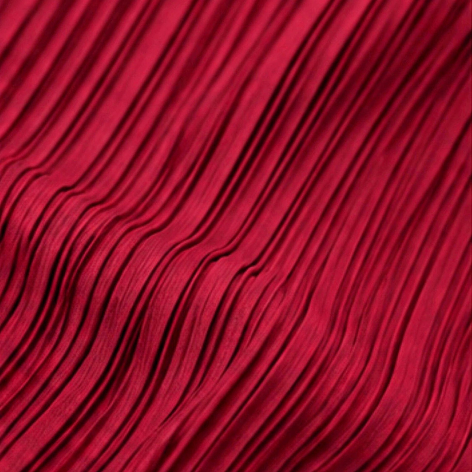 Close-up view of burgundy pleated polyester fabric showing the textured lightweight material and fine pleat detail