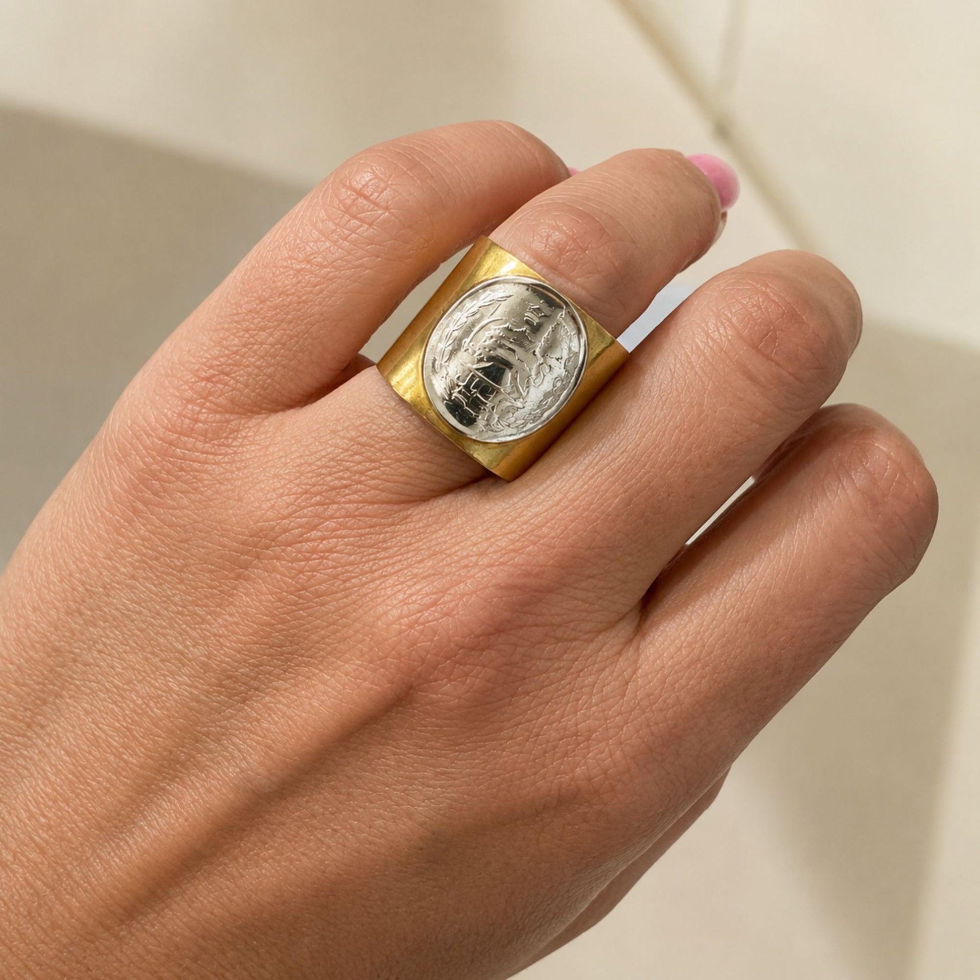 Gold ring with a silver coin inset 