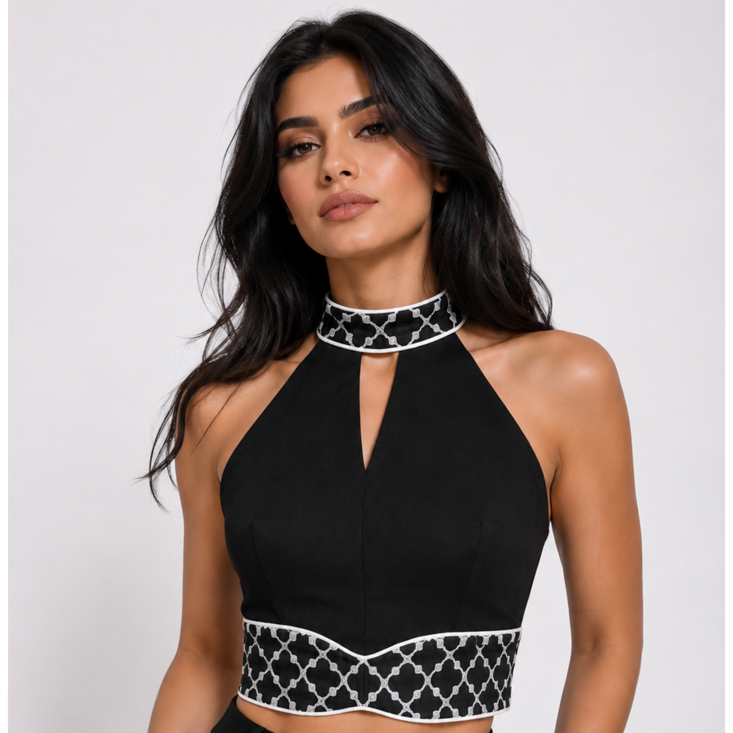 Woman wearing a black halter top with white patterned trim 