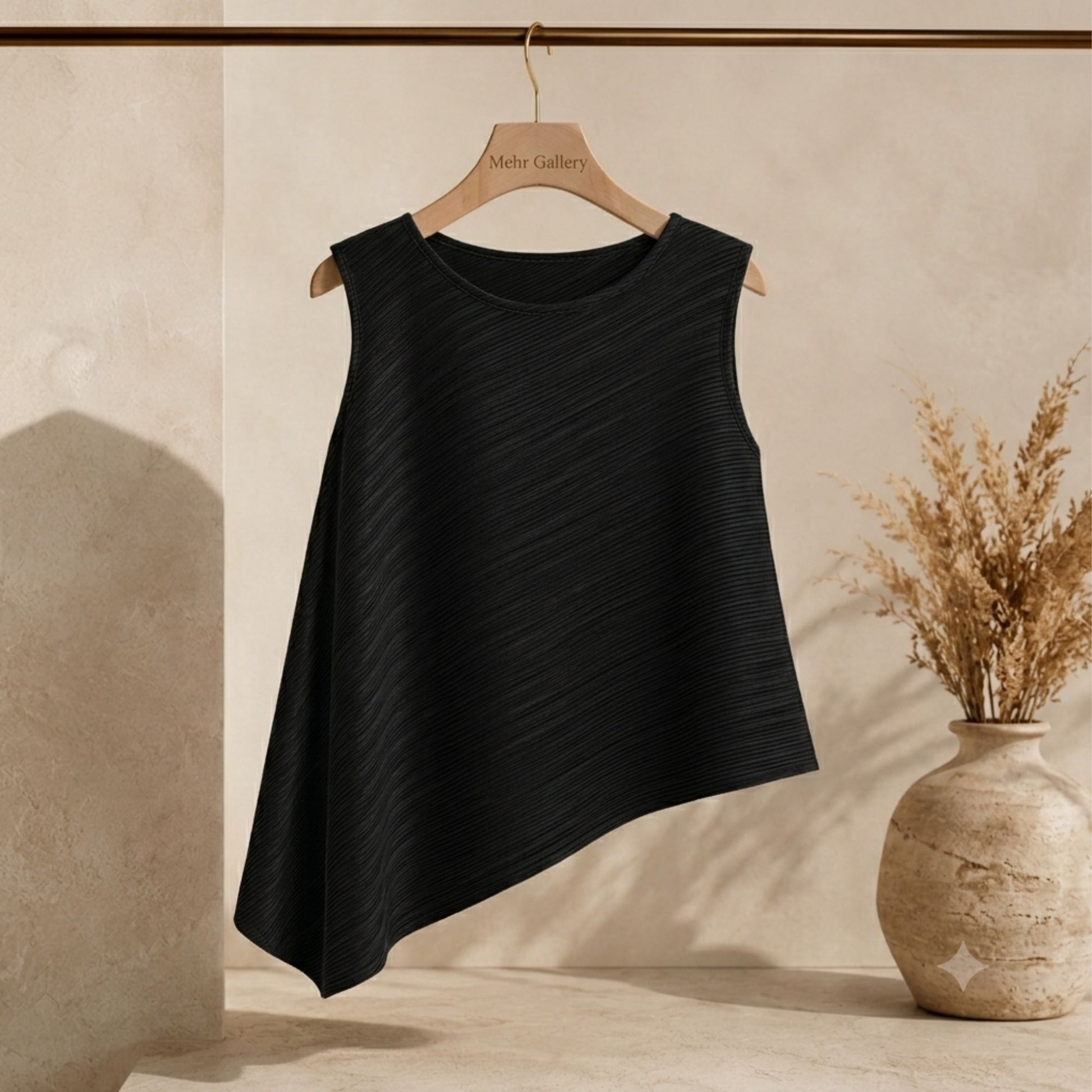 Burgundy pleated sleeveless top displayed on a hanger featuring an asymmetric hemline, crew neck, and wrinkle-resistant fabric