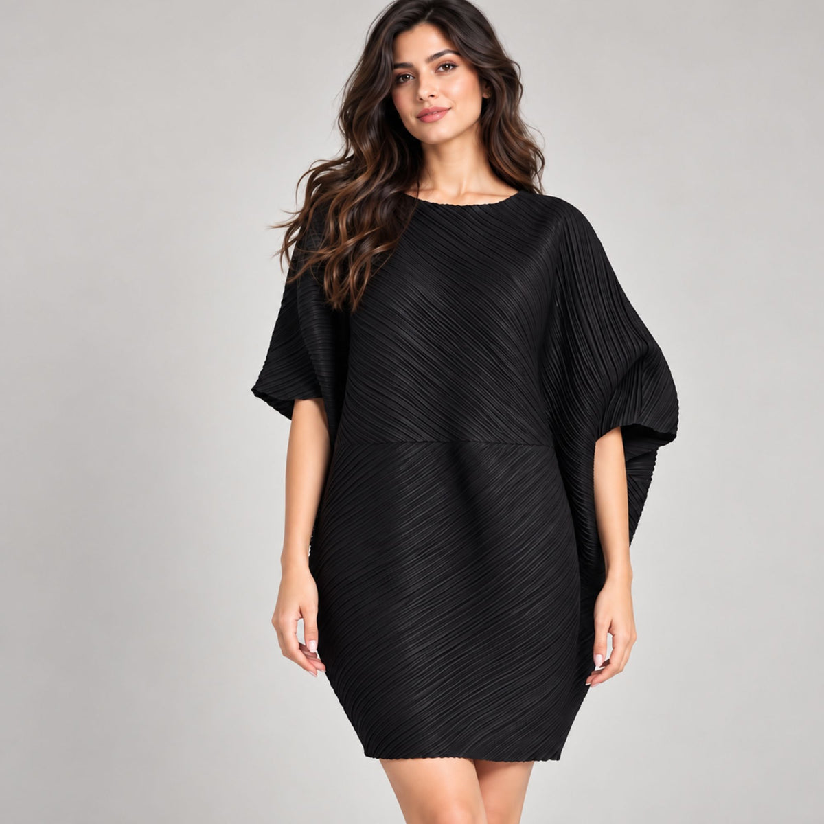 Woman wearing a black pleated short dress with relaxed batwing sleeves