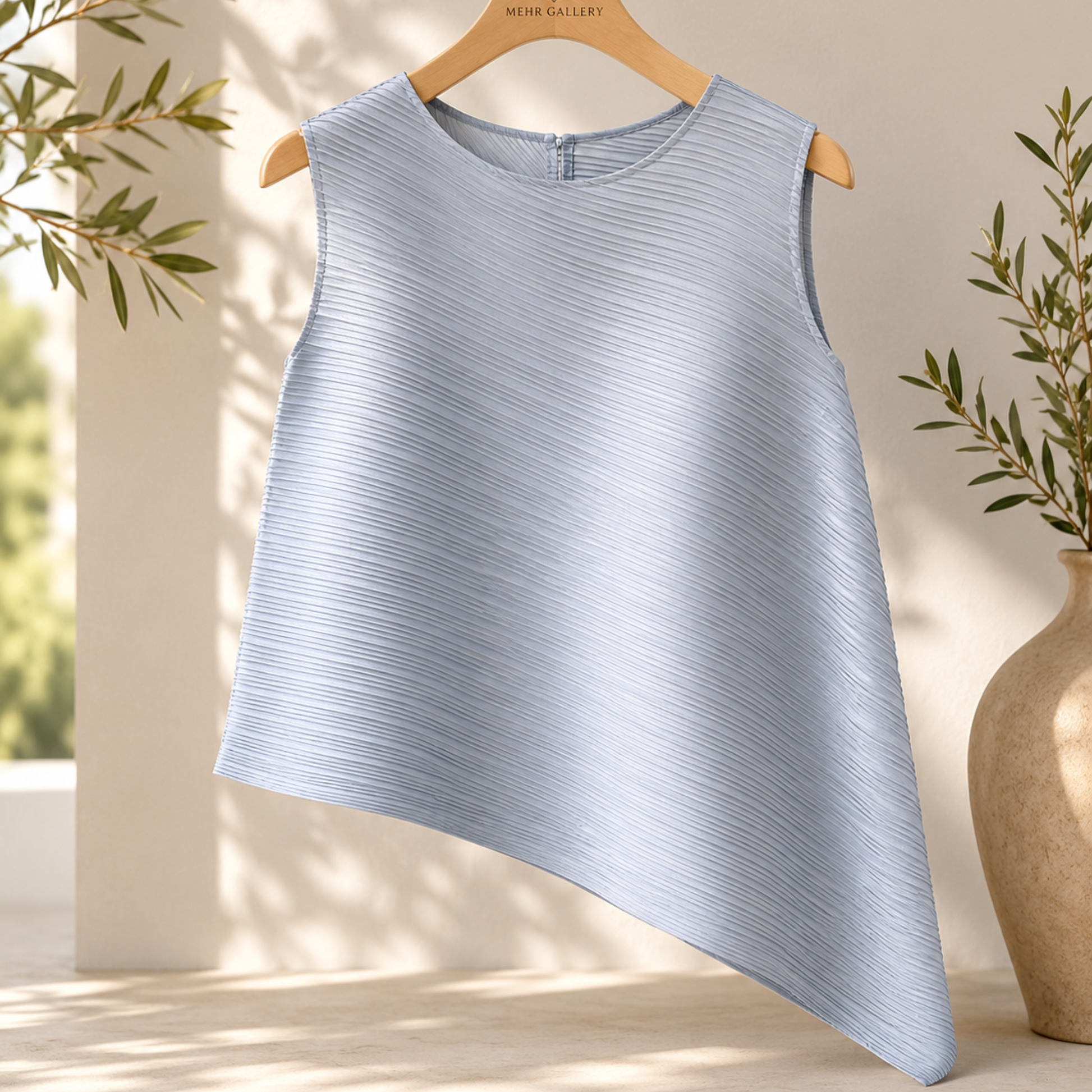 Burgundy pleated sleeveless top displayed on a hanger featuring an asymmetric hemline, crew neck, and wrinkle-resistant fabric.