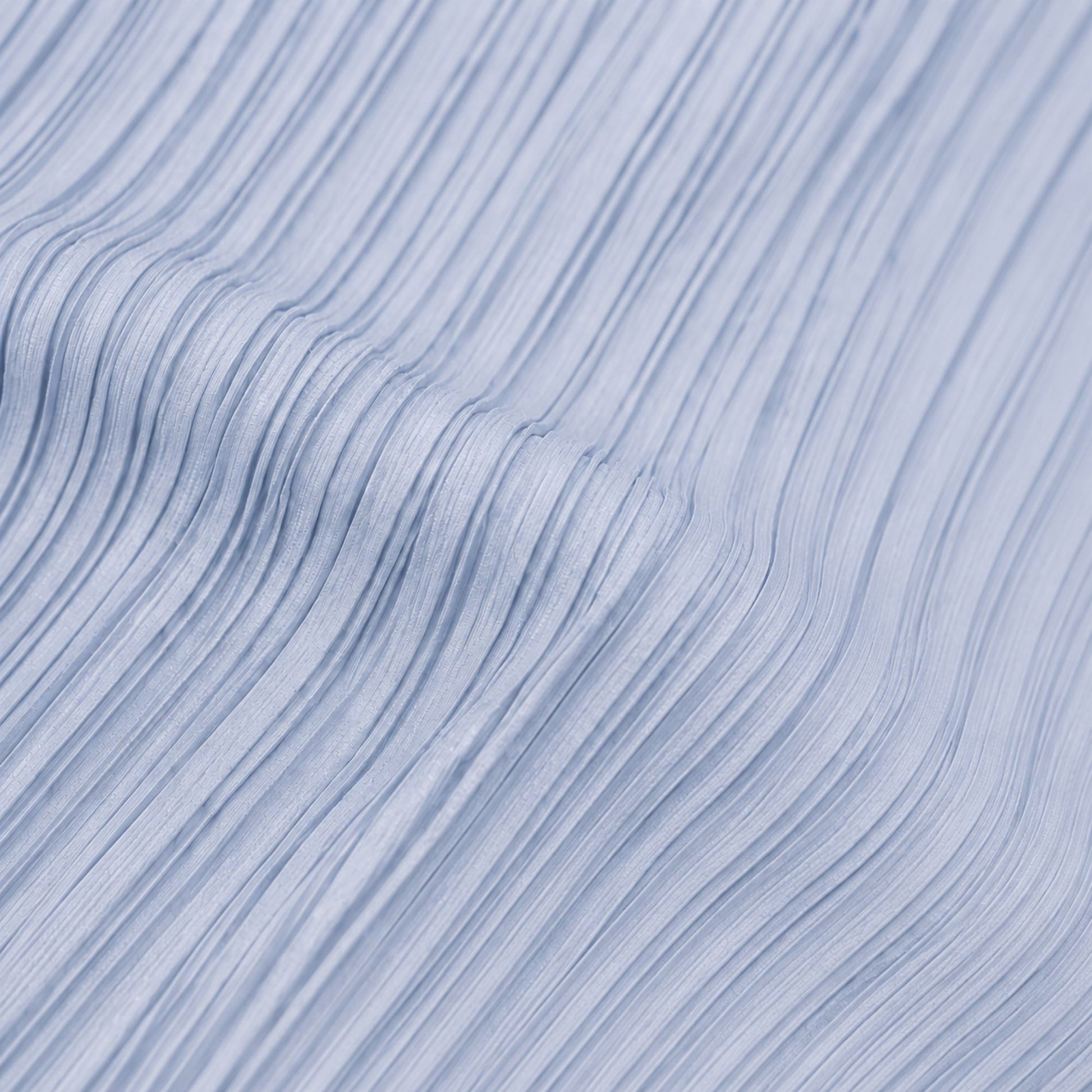 Close-up view of blue pleated polyester fabric showing the textured lightweight material and fine pleat detail.