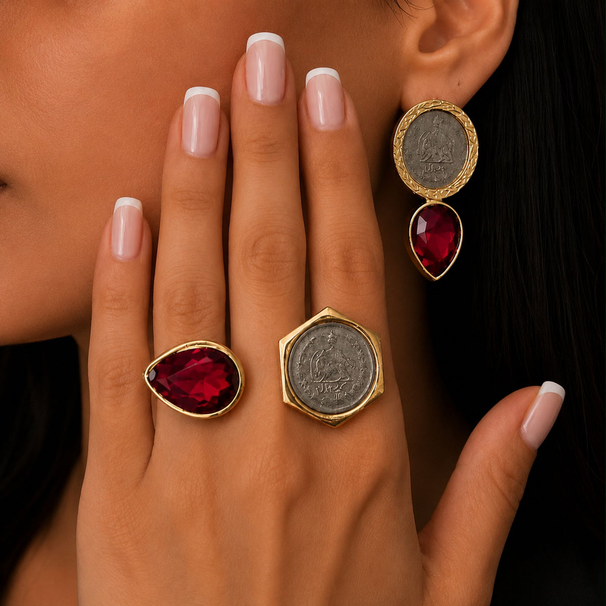 Model wearing matching coin ruby red earrings and matching adjustable fashion ring with a gold-tone finish.