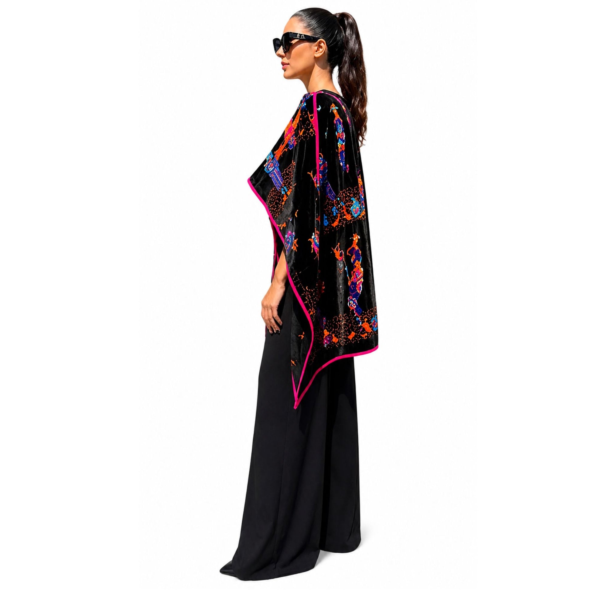 Side view of black velvet poncho with vibrant embroidery and relaxed drape fit