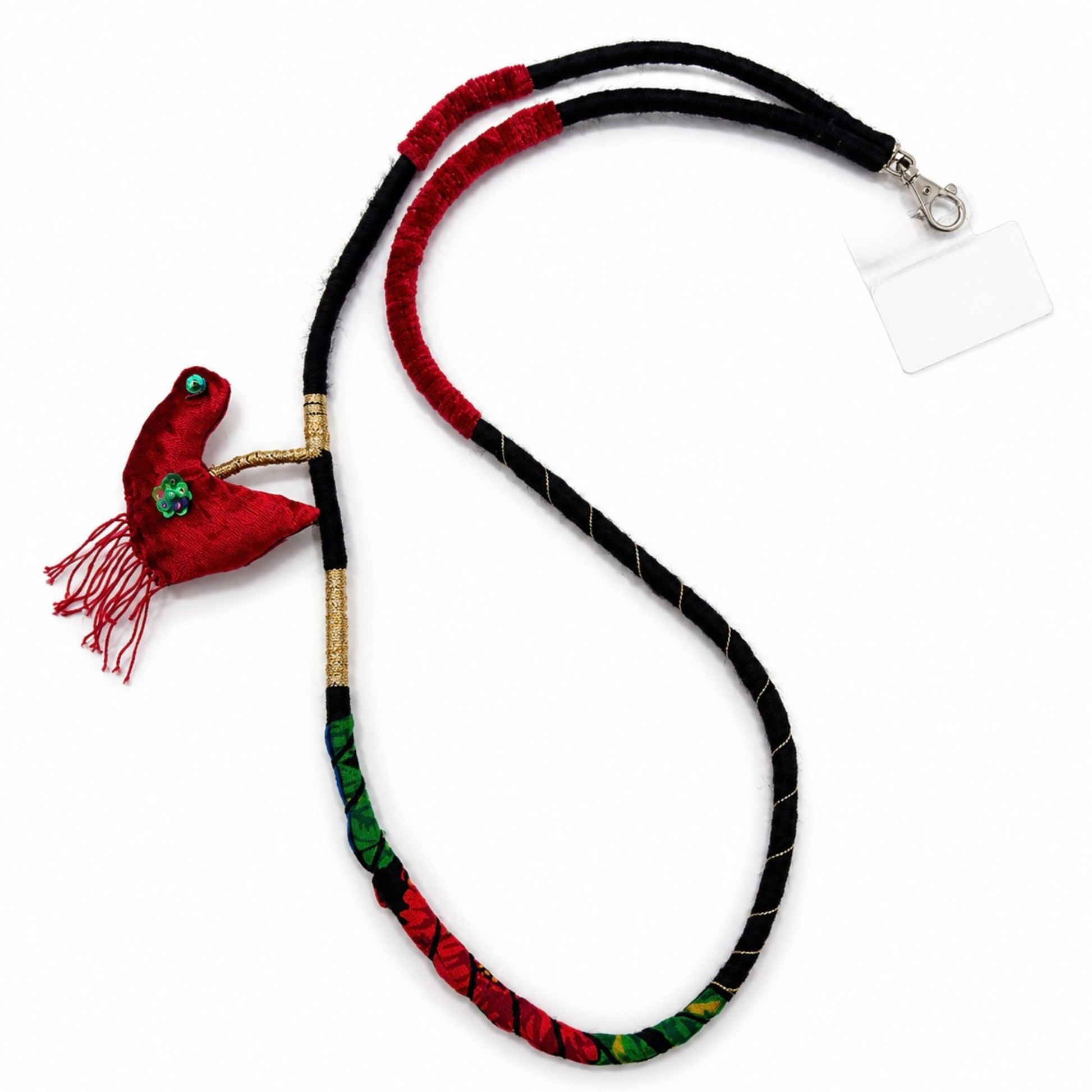 Detailed view of a handcrafted red textile bird charm with tassel accents on a wearable phone strap necklace.
