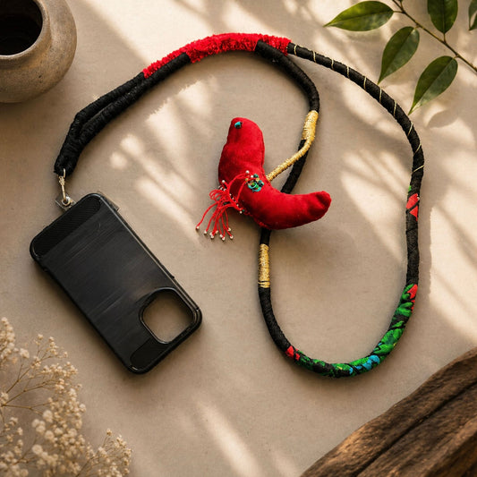 Unique artisan bird charm attached to a long handmade phone lanyard crafted from fabric and decorative thread.