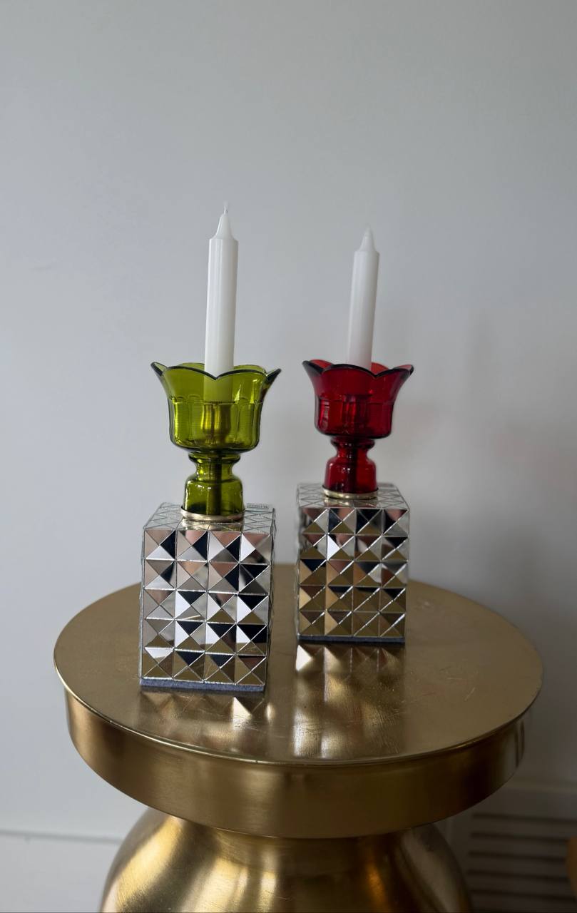 Handcrafted mirror mosaic glass candle holders in Ruby Red and Light Olive Green displayed on a gold coffee table.