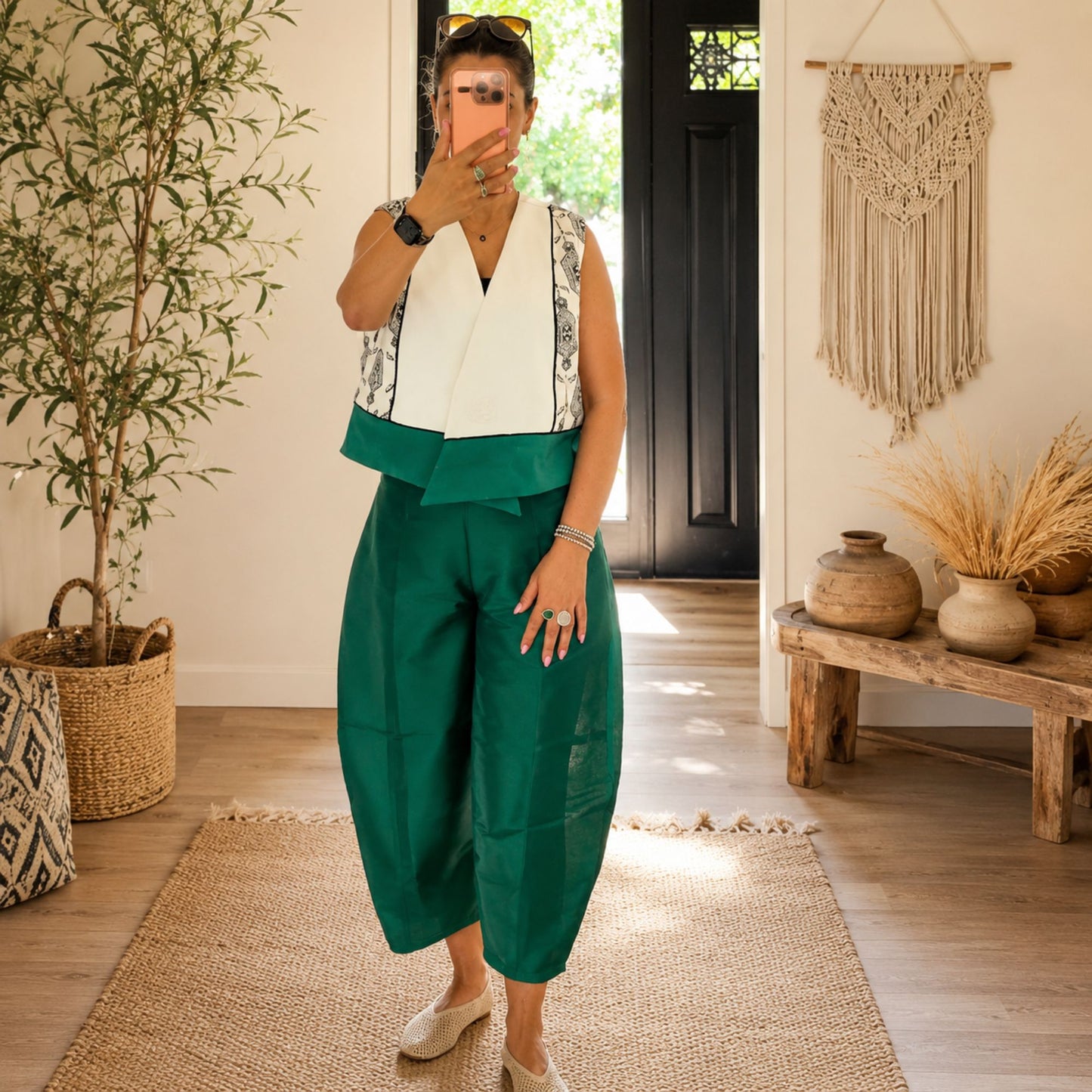 Women's handmade geometric color-block open-front vest styled with emerald green wide-leg pants in a modern boho outfit.