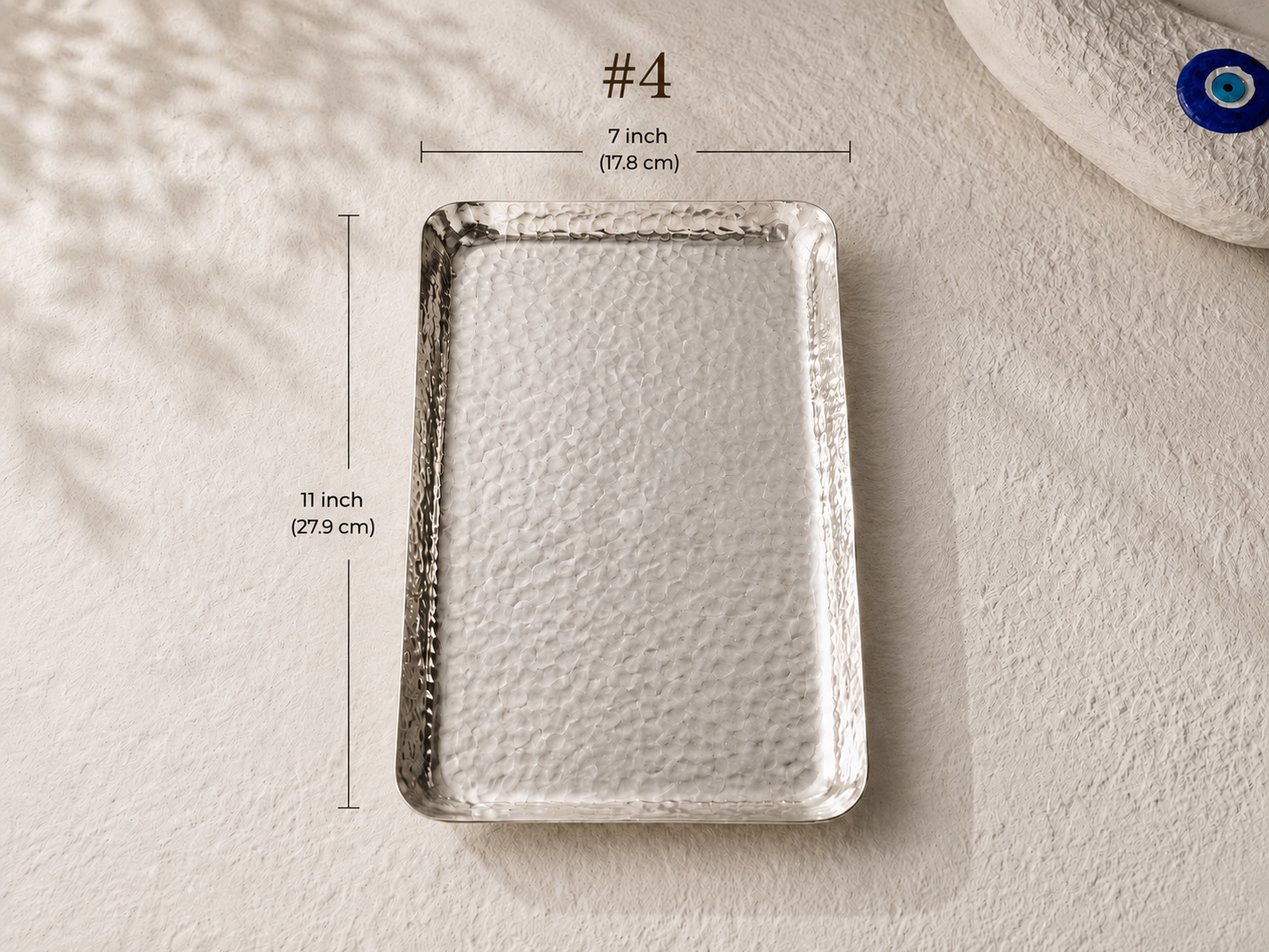 A hammered rectangular tray shown on a textured off-white surface with dimension lines and text indicating measurements of 7 inch by 11 inch (#4).