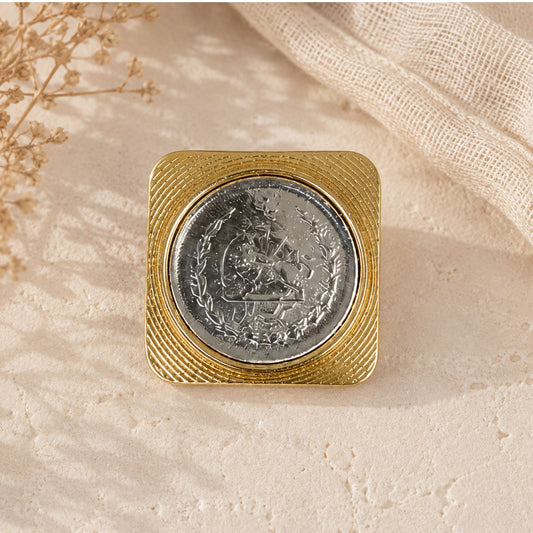 Silver coin with a gold square border