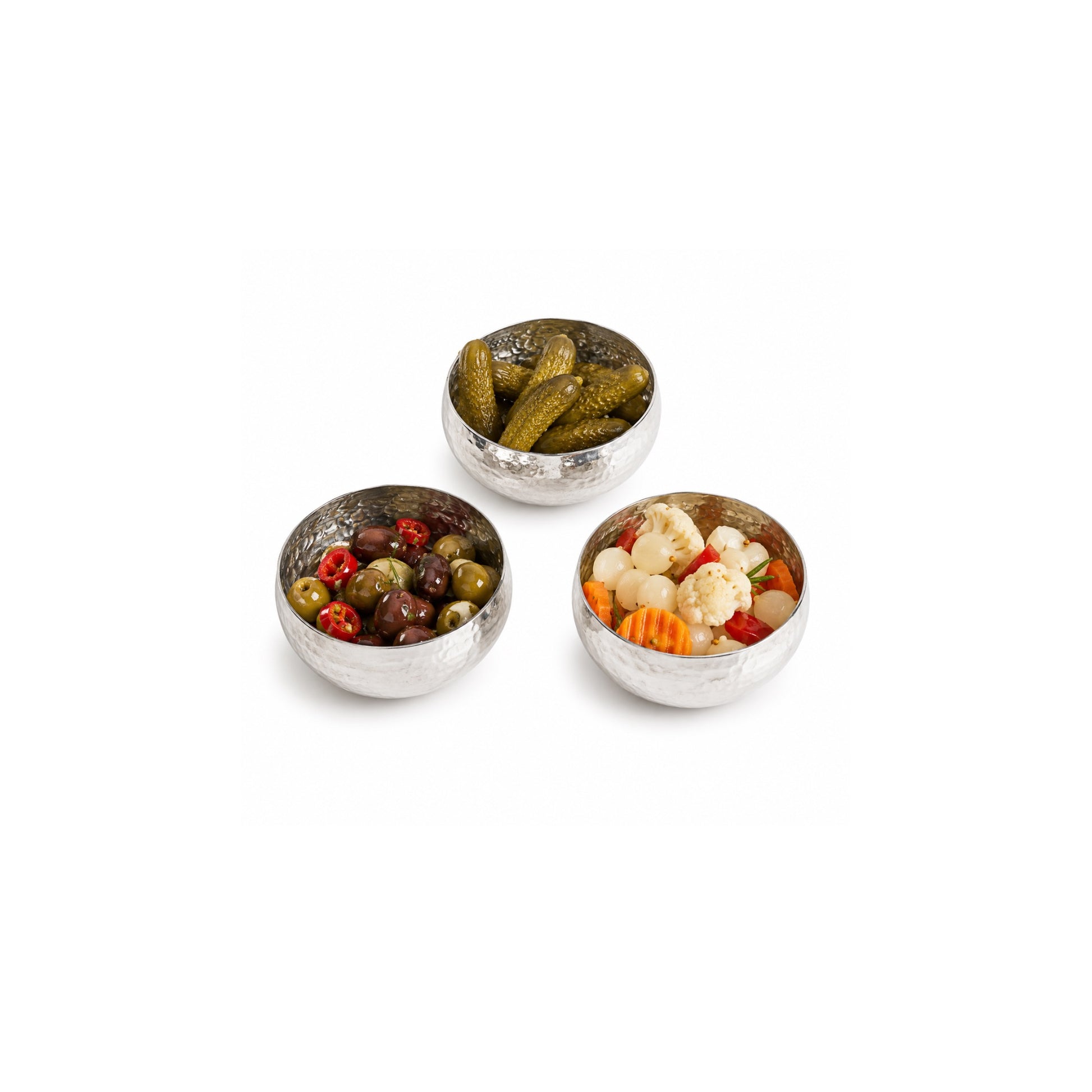 Mini handcrafted hammered white copper bowls filled with assorted pickles and olives.