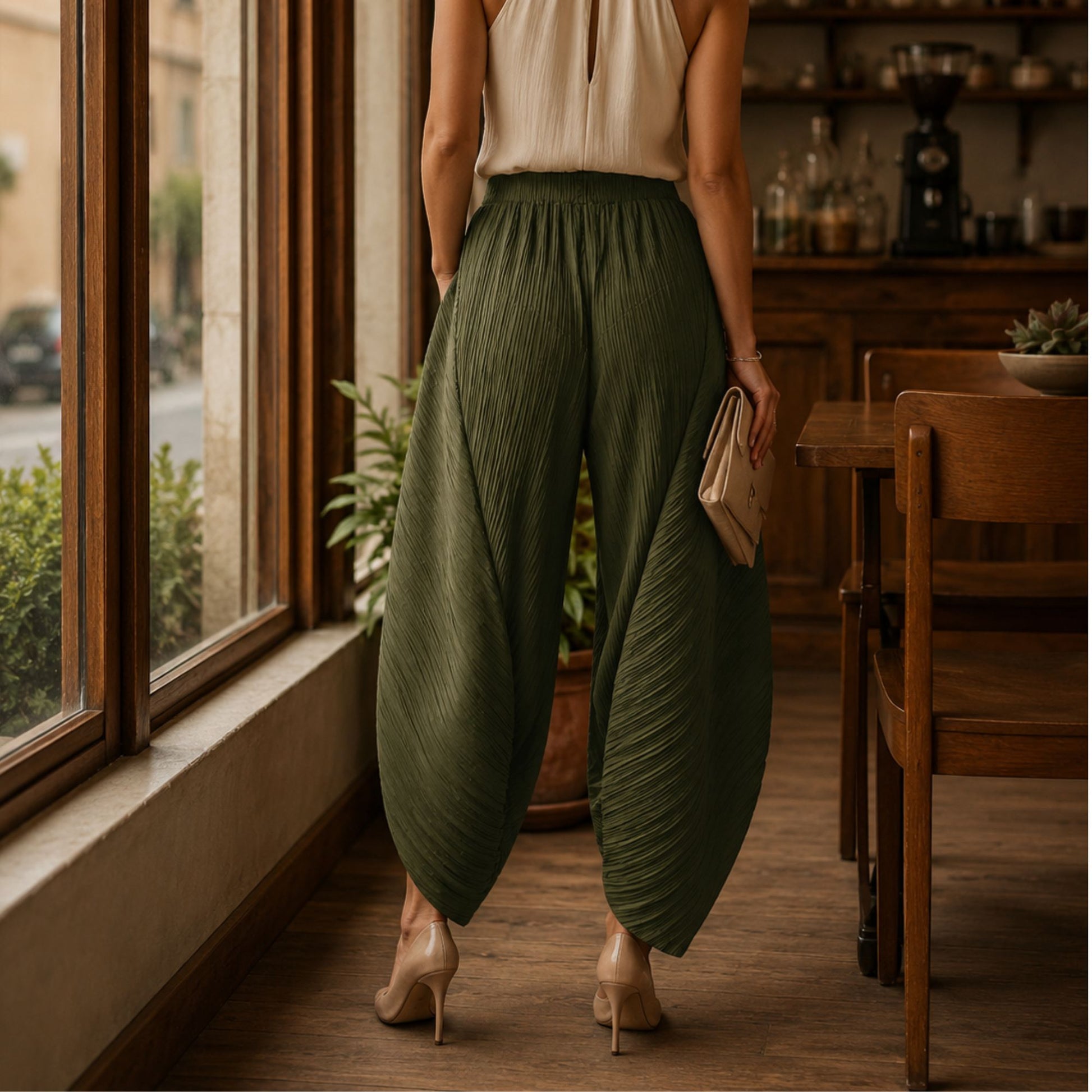 Back side of a person wearing green wide-leg  pleate pants.