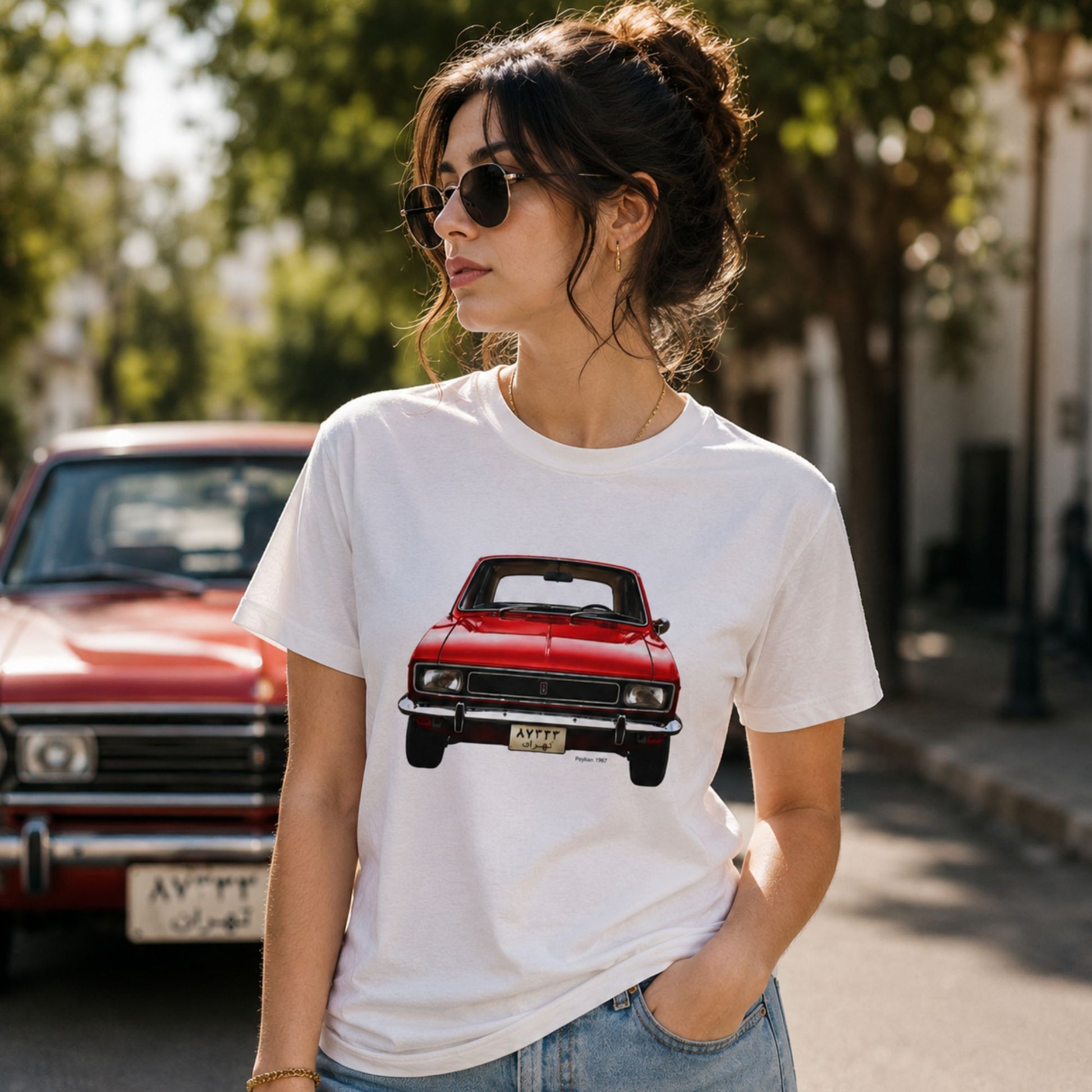 Female model wearing a Vintage Peykan 1967 graphic t-shirt with a red classic Persian car illustration on a white cotton unisex shirt